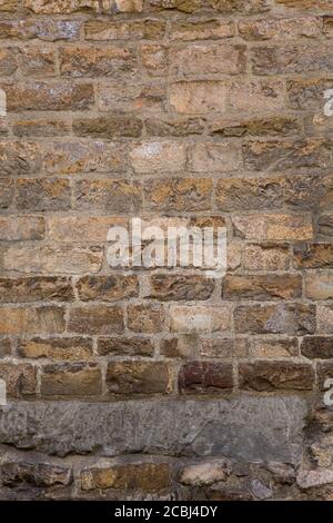 Retro brick wall. Masonry or brickwork of weathered antique architecture construct. Texture or background. Vertical format Stock Photo