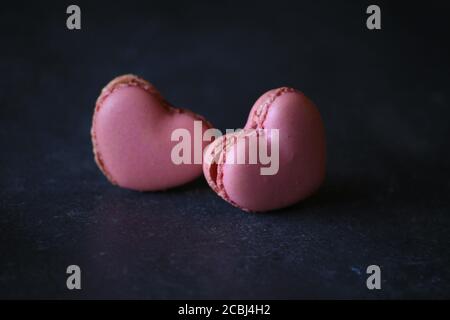 heart-shaped macaroons on dark background. Macaroons Heart. Valentine's Day. Stock Photo