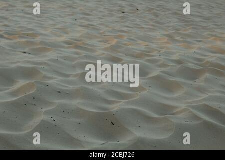 sand uneven waves highlighted by the sun sand background on the sea river lake summer Stock Photo