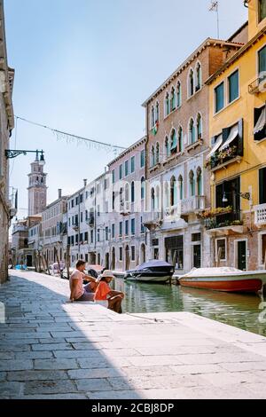 couple men and woman on a city trip to Venice Italy, colorful streets with canals Venice Stock Photo