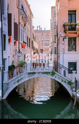 couple men and woman on a city trip to Venice Italy, colorful streets with canals Venice Stock Photo