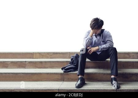 Man office worker sitting on stair and stressed from layoff during the crisis Stock Photo