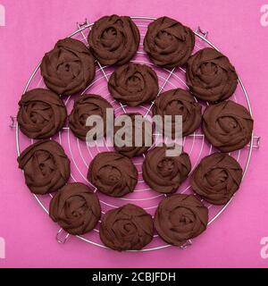 Chocolate viennesewhirls cookies on round shape	grid, with pink background Stock Photo