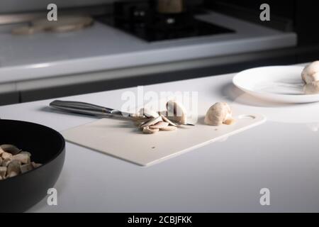 cutting white plastic board with champignon mushrooms on it. cooking process. High quality photo Stock Photo