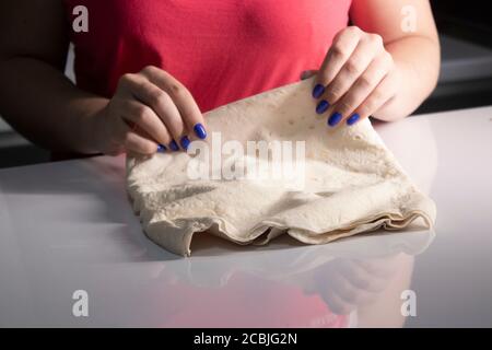 girl's hands prepare pita bread in a gray kitchen on a white table top. cooking process. High quality photo Stock Photo