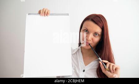 Artist woman holds in her hands empty canvas pad. Negative space or copy space for text or logo. Stock Photo