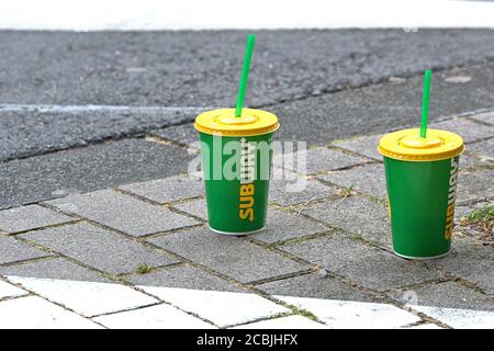 August 1st, 2020, Kiel, improperly disposed of, green Subway paper cups with yellow plastic lids and green plastic straw lambs, which were simply placed on a sidewalk in Kiel. --- For editorial use only! --- Only for editorial use! --- | usage worldwide Stock Photo