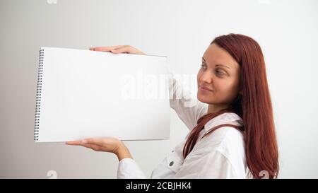 Caucasian woman holds in her hands empty canvas pad. Stock Photo