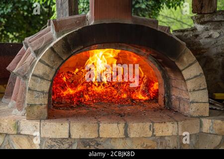 Burning oak wood in a furnace. Stove in country house. Bright flame over hot coals. Stock Photo