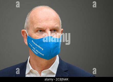 14 August 2020, Brandenburg, Potsdam: Dietmar Woidke (SPD), Minister President of Brandenburg, wears a blue mouth-nose guard with the inscription 'Brandenburg - also beautiful by far' during his press tour in the Barberini Museum. During the closing phase of the museum, there was a preview of the new exhibition 'Impressionism. The Hasso Plattner Collection', which will open on 07.09.2020. Potsdam is thus to become one of the most important centres of collections of Impressionist landscape painting worldwide outside of Paris. Photo: Soeren Stache/dpa-Zentralbild/ZB Stock Photo