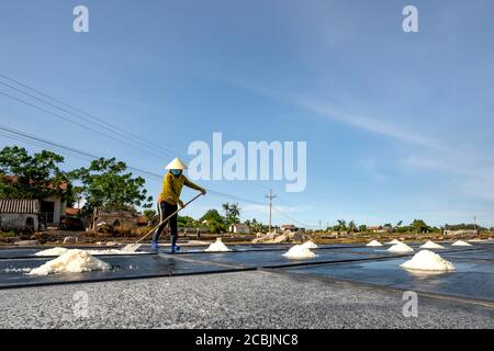 Nghe An province, Vietnam - July 30, 2020: Image of a woman making salt in Nghe An province, Vietnam Stock Photo