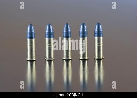 Five 22 long rifle rimfire cartridge on a table Stock Photo