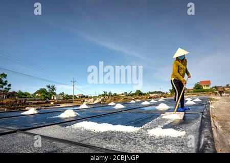 Nghe An province, Vietnam - July 30, 2020: Image of a woman making salt in Nghe An province, Vietnam Stock Photo