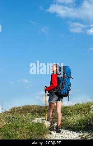 Smiling hiking young woman on the mountain trail Stock Photo