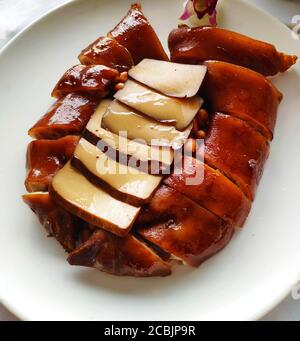 red Braised pig feet with white dried bean curd on the white plate Stock Photo