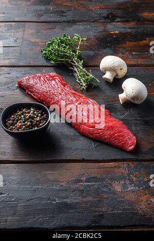 Tri tip steak with fresh seasoningsm thyme, organic tri-tip roast with fat marbled through the meat ready to roast or barbecue on wooden background Stock Photo