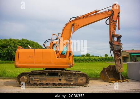 A crawler excavator with a rotating house platform and continuous caterpillar track on a sewer replacement work site in north west Italy Stock Photo