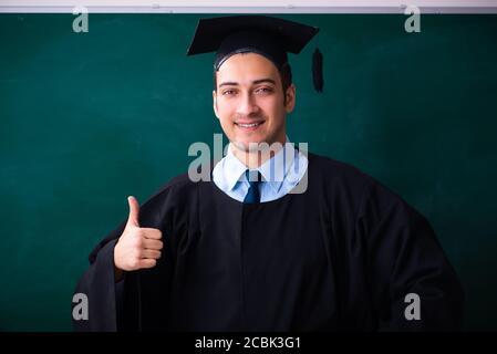 Young male graduate in front of the board Stock Photo