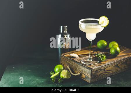 Margarita cocktail with lime and ice on minton dark wooden table with amazing backlight, copy space. Classic Margarita or Daiquiry Cocktail. Stock Photo