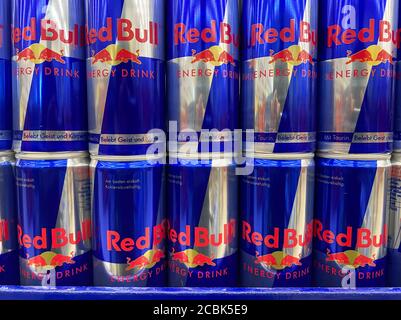 Viersen, Germany - July 9. 2020: View on isolated stacked blue cans of Red Bull energy drink in shelf of german supermarket Stock Photo
