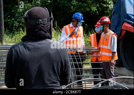 Kuala Lumpur, Malaysia. 12th Aug, 2020. Hakimi Razak (2nd, L), a QAQC manager for China Communications Construction Company (CCCC), works at a bridge construction site of the East Coast Rail Link (ECRL) in Pahang state, Malaysia, Aug. 12, 2020. TO GO WITH: 'Feature: Constructions of Malaysia's railway megaproject ECRL back to full swing with strong precautions measures against COVID-19' Credit: Zhu Wei/Xinhua/Alamy Live News Stock Photo