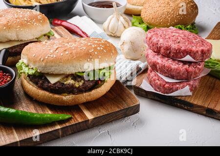 Hamburger and raw ingredients on white textured background Stock Photo