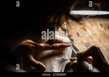 hands of artisan woman violin maker luthier working in the back table of a new hand made cremonese violin Stock Photo