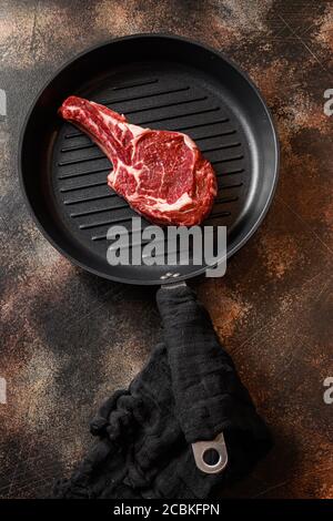 Cowboy steak on the grill pan or tomahawk steak raw top view. ove rustic metal dark background table Stock Photo