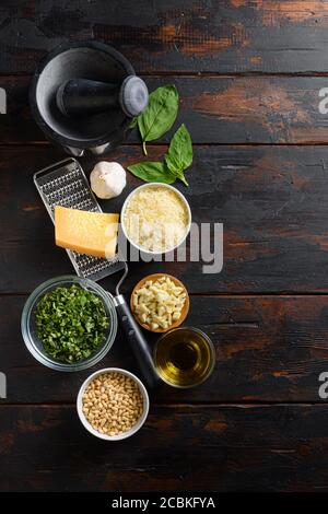 Fresh ingredients for pesto genovese Italian food cooking ingredients on dark background with rustic wooden chopping board, top view, vertical copy Stock Photo