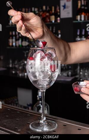 The bartender prepares a cocktail in the restaurant bar. The process of pouring alcohol into a glass Stock Photo