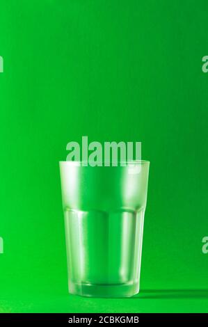 Empty glass on a green background, selective focus. Stock Photo