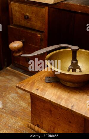 Antique aged manual wooden coffee grinder, kitchen interior, old drawer closet at background Stock Photo