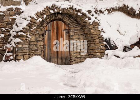 Small door made of stones during winter time Stock Photo