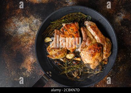 Grilled organic pork cutlets with herbs on bone in grill frying pan hot with smoke and hot oil just from fire, top view cooking bone with seasonings Stock Photo