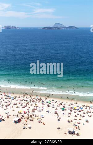 Tourists on beach, Cagarras islands in distance, Ipanema, Rio de Janeiro, Brazil Stock Photo