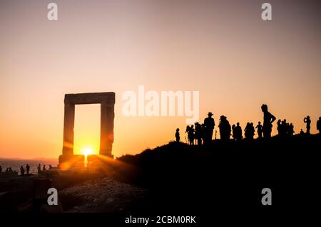 Silhouetted tourists watching sunset at Temple of Apollo, Naxos Island, Greece Stock Photo