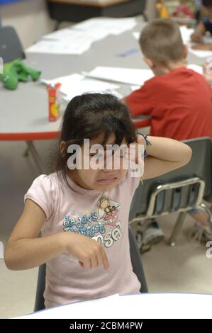 Mabank, Texas USA, August 21, 2006: An upset Hispanic kindergartner wipes away tears during the first week of school at Mabank Central Elementary. ©Bob Daemmrich Stock Photo