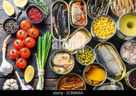 Canned preserves food in tin open cans. with fresh organic ingridients Saury, mackerel, sprats, sardines, pilchard, squid, tuna pinapple, corn, peas Stock Photo