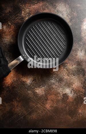 empty cast-iron grill pan skillet and linen cloth on metal rustic table top view space for text. Stock Photo