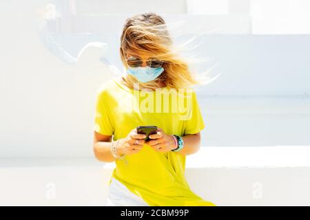 businesswoman with face mask working using phone Stock Photo