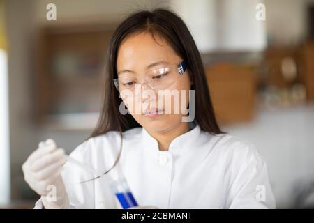 scientist female with lab glasses and tubes in a lab Stock Photo