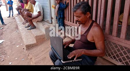 DISTRICT KATNI, INDIA - OCTOBER 23, 2019: An indian village labor learning laptop at open area background, concept for digital learning technology awa Stock Photo