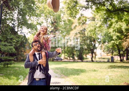 Father giving daughter piggyback ride after school Stock Photo