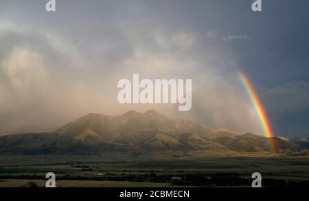 A summer rainbow rises over the Paradise Valley in Emigrant, Montana. Stock Photo
