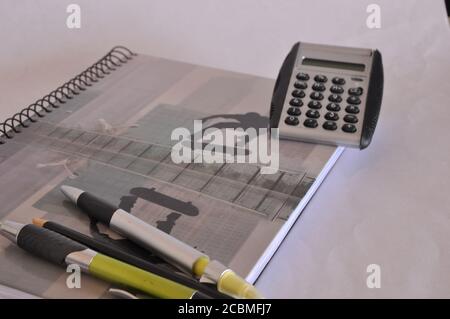 Writing notebook with colored cover, glasses, pen, non-digital calculator and pencil on white background, conceptual photo, back to school, Brazil, So Stock Photo