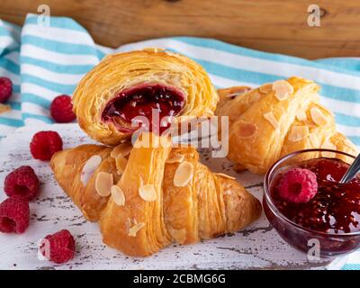 Yummy freshly croissant, with raspberries jam filling cut, close up Stock Photo