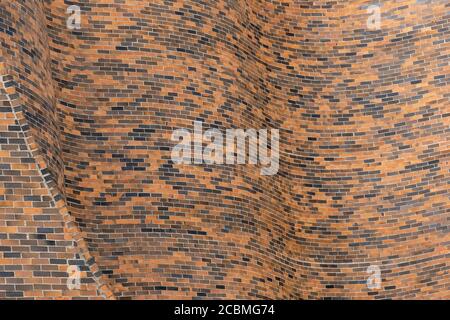 Curving brick wall provides interesting texture and pattern for abstract background. Stock Photo