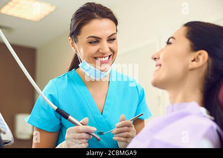The dentist and the patient are smiling at the dental clinic. Stock Photo