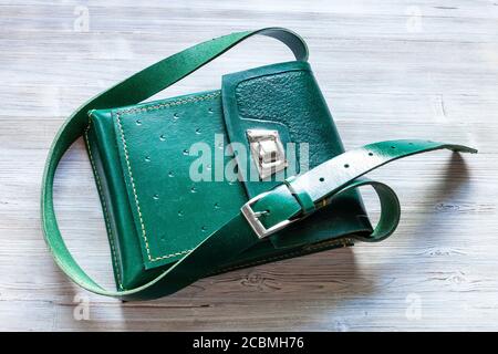 top view of handmade green leather tablet bag on gray wooden table Stock Photo