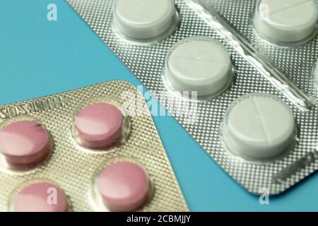 Red and white pills on blue background top view Stock Photo